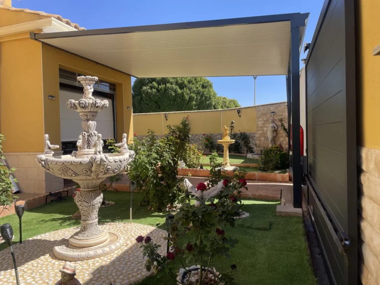Pérgola de aluminio con cubierta de lamas blancas sobre una zona de jardín