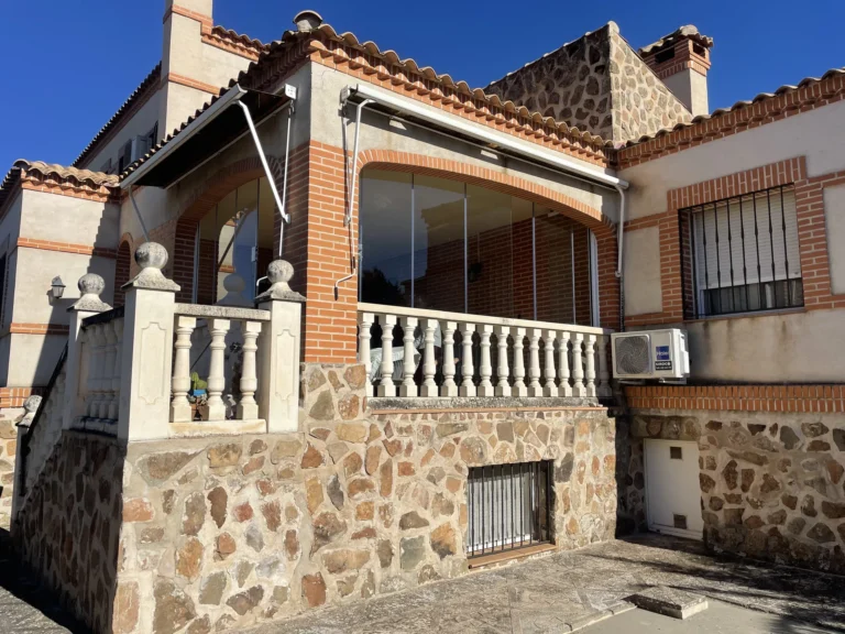 Porche con arcos de ladrillo cerrado con paneles de cristal